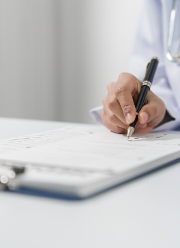 Doctor writing on patient chart